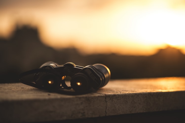 Image of a pair of binoculars looking at sunset.
