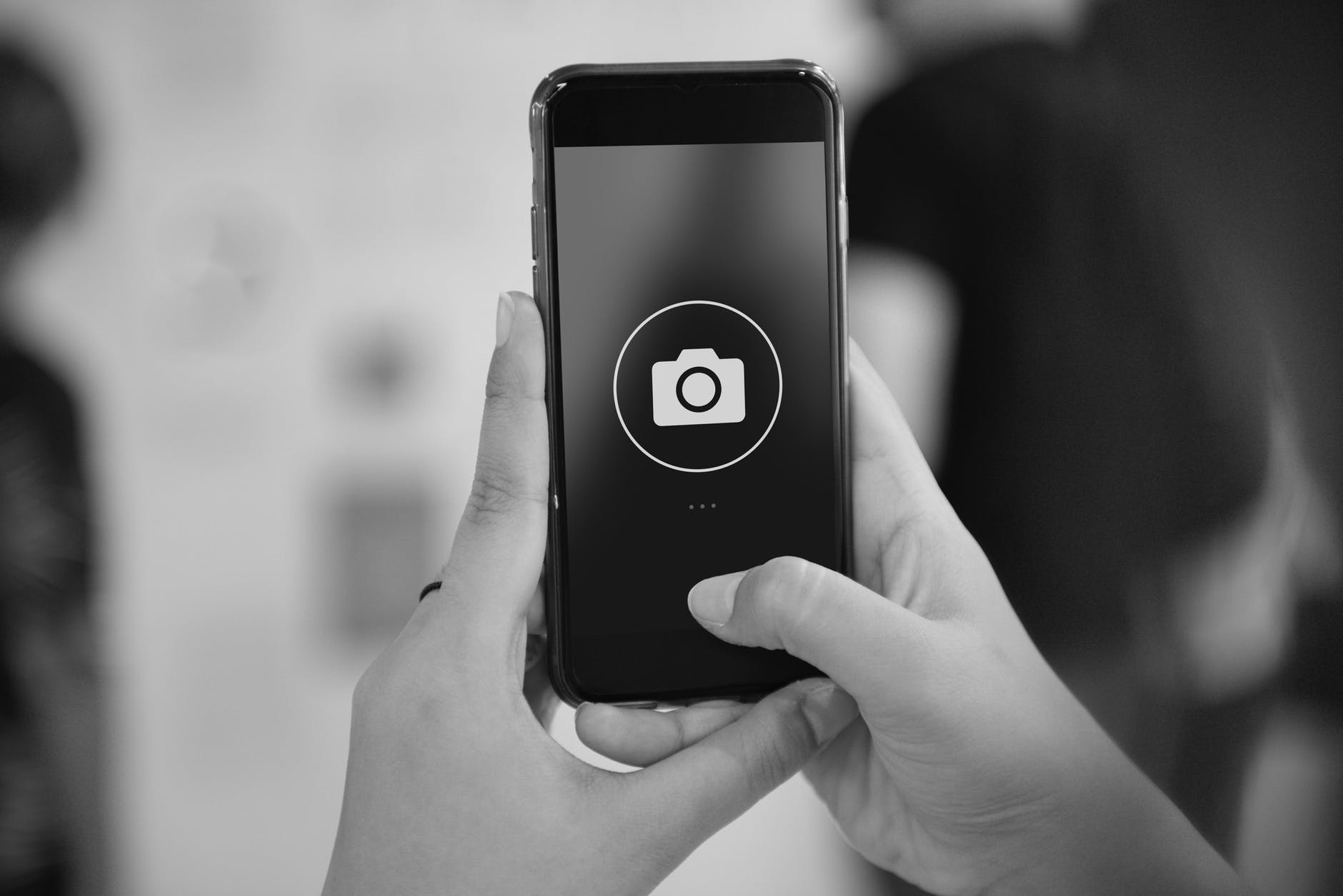 Photo of hands holding a camera phone.